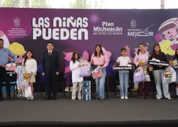 Niñas en evento de Michoacán recibiendo regalos y reconocimiento en una ceremonia oficial.