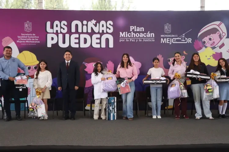 Niñas en evento de Michoacán recibiendo regalos y reconocimiento en una ceremonia oficial.