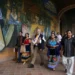 Personas caminando frente a mural colorido en evento cultural en Michoacán.