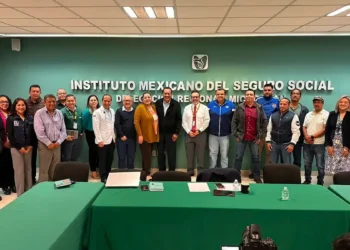 Grupo de profesionales y funcionarios en una reunión en la oficina del IMSS en Michoacán.