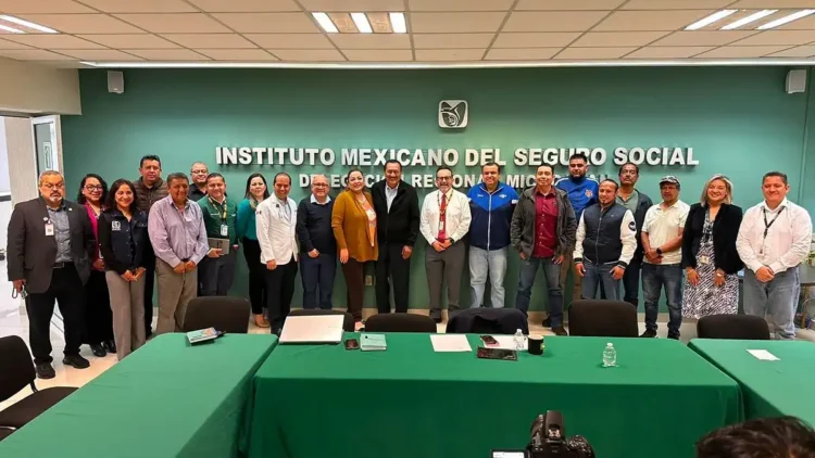 Grupo de profesionales y funcionarios en una reunión en la oficina del IMSS en Michoacán.