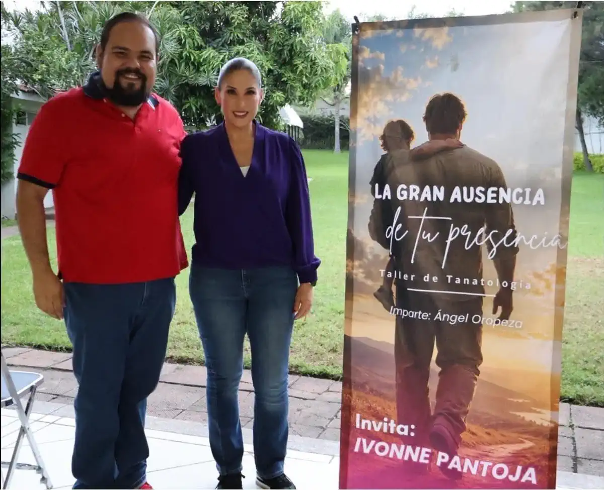 Dos personas en un taller de tanatología en Zamora, con un cartel que dice La Gran Ausencia de tu Presencia.