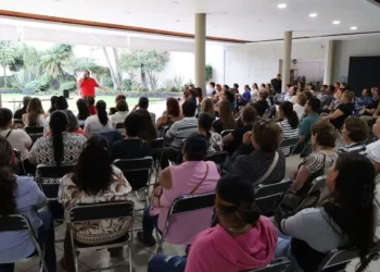 Grupo de personas en taller de tanatología en Zamora, asistiendo a una conferencia en un espacio amplio y luminoso.