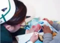 Recien nacido en incubadora con personal médico y familiares en fondo blanco.