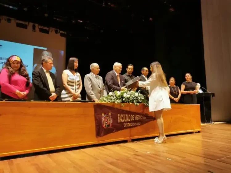 Estudiantes y profesores en ceremonia en la Facultad de Medicina de la Universidad Michoacana, en un acto de reconocimiento a.