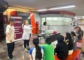 Estudiantes participando en un taller de ciencia en la Universidad Nacional de Rosario, con una instructora explicando concep.