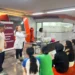 Estudiantes participando en un taller de ciencia en la Universidad Nacional de Rosario, con una instructora explicando concep.