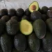 Aguacates frescos de Michoacán con uno partido mostrando su interior verde y semilla.