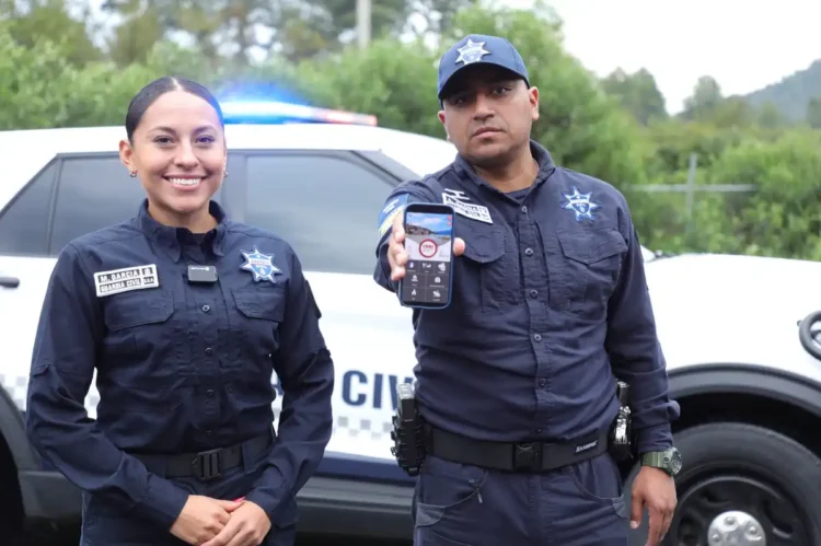 Policías muestran un teléfono móvil con una aplicación de bloqueo de llamadas de extorsión en Michoacán.