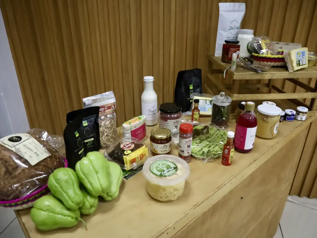 Variedad de productos orgánicos en una mesa de madera, incluyendo verduras, frascos y paquetes de alimentos naturales.