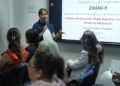 Mujer dando capacitación en un aula con pantalla para examen de ingreso a Normales en Michoacán.