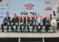 Funcionarios y expertos en evento oficial en Michoacán, sentados en una mesa con fondo de logotipos y cartel.