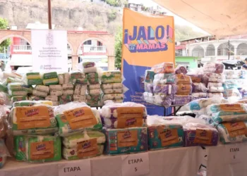 Paquetes de pañales en una mesa con cartel de Jalo por las Mamas en Morelia.