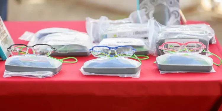 Lentes de diferentes colores y estilos en una mesa con empaques y accesorios para estudiantes en Michoacán.