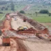 Maquinaria y trabajadores en construcción de libramiento en Michoacán, con maquinaria pesada y tierra en movimiento.