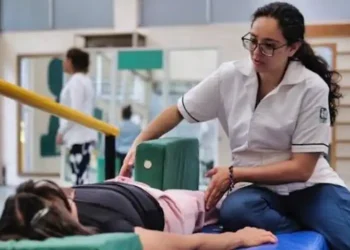 Fisioterapeuta ayuda a paciente en sesión de rehabilitación en clínica del IMSS Michoacán.