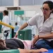 Fisioterapeuta ayuda a paciente en sesión de rehabilitación en clínica del IMSS Michoacán.