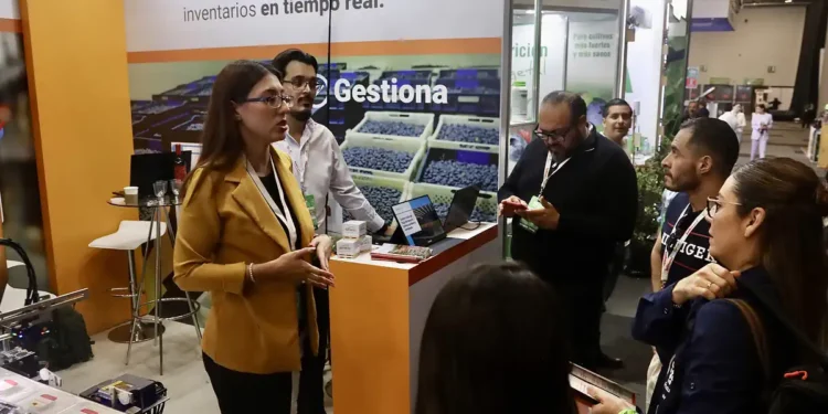 Grupo de profesionales discutiendo sobre gestión de inventarios en feria tecnológica en Jalisco.