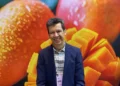 Hombre sonriendo con fondo de mangos maduros y en cubos en Jalisco.