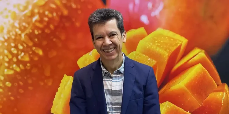 Hombre sonriendo con fondo de mangos maduros y en cubos en Jalisco.