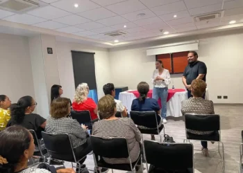 Grupo de personas en taller de tanatología en Zamora, con dos facilitadores en el frente de la sala.