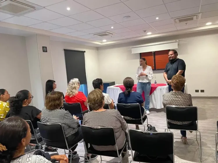 Grupo de personas en taller de tanatología en Zamora, con dos facilitadores en el frente de la sala.