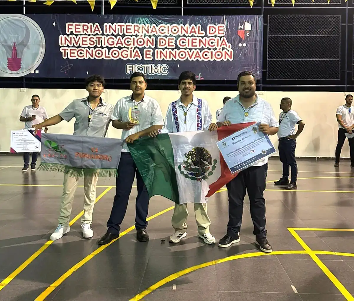 Cuatro jóvenes sosteniendo una bandera de México y un premio en la Feria Internacional de Ciencia y Tecnología.