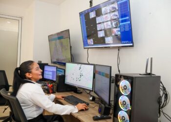 Operadora monitorea alertas en sistema de seguridad con múltiples pantallas en Morelia.