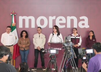Gladyz Butanda en evento de Morena, con varios líderes y cámaras en primer plano.