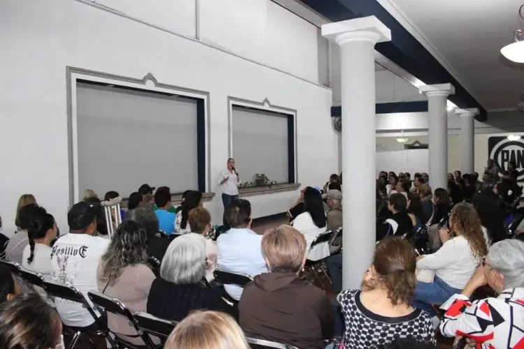 Conferencista en un taller de tanatología frente a una audiencia en un auditorio.