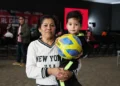 Mujer y niño con balón en evento de apoyo a familias con niños con cáncer en Michoacán.
