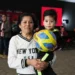 Mujer y niño con balón en evento de apoyo a familias con niños con cáncer en Michoacán.