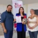 Tres personas en ceremonia de reconocimiento, una con certificado y regalo, en evento de familias de acogida en Michoacán.