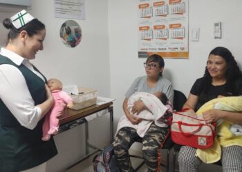 En IMSS Michoacán, una enfermera muestra a madres la importancia de la lactancia materna.