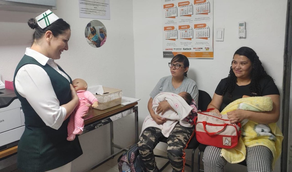 En IMSS Michoacán, una enfermera muestra a madres la importancia de la lactancia materna.