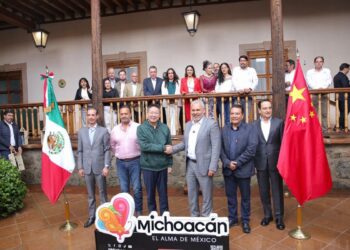 Funcionarios y líderes en Michoacán posan con banderas de México y China en evento oficial.
