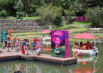 Lanchas eléctricas en Pátzcuaro con turistas y comunidad local en un muelle.