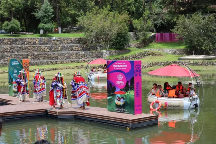 Lanchas eléctricas en Pátzcuaro con turistas y comunidad local en un muelle.