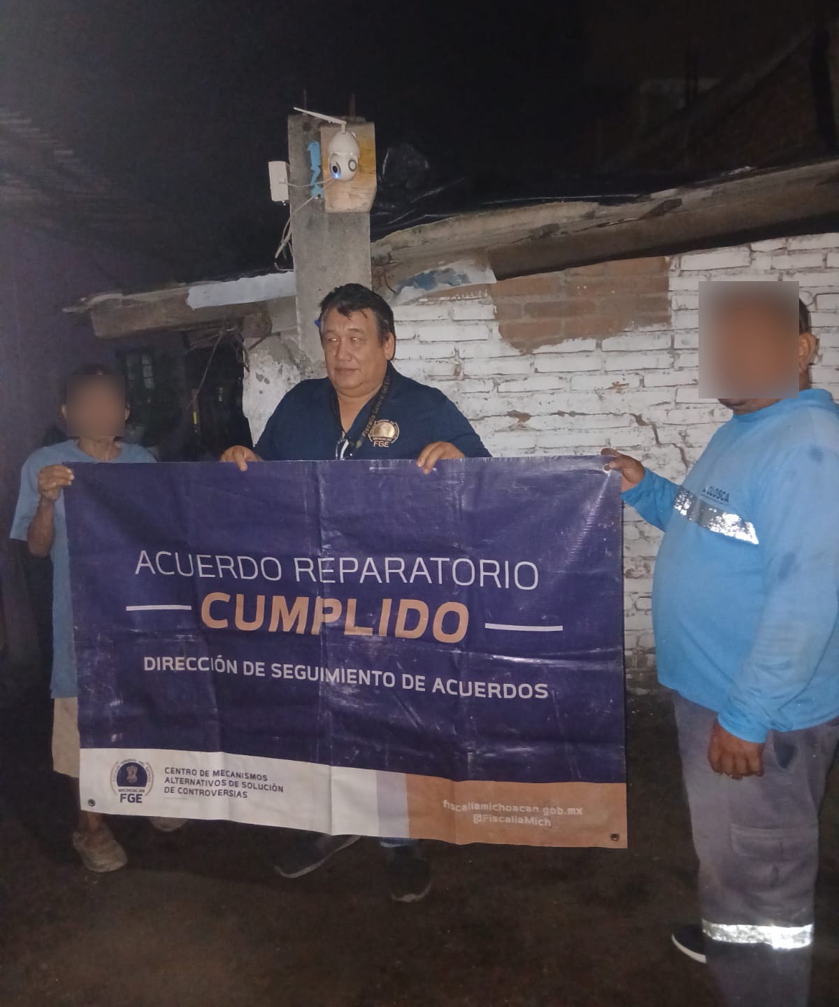 Autoridades y ciudadanos sostienen cartel de acuerdo cumplido en Michoacán durante la noche.