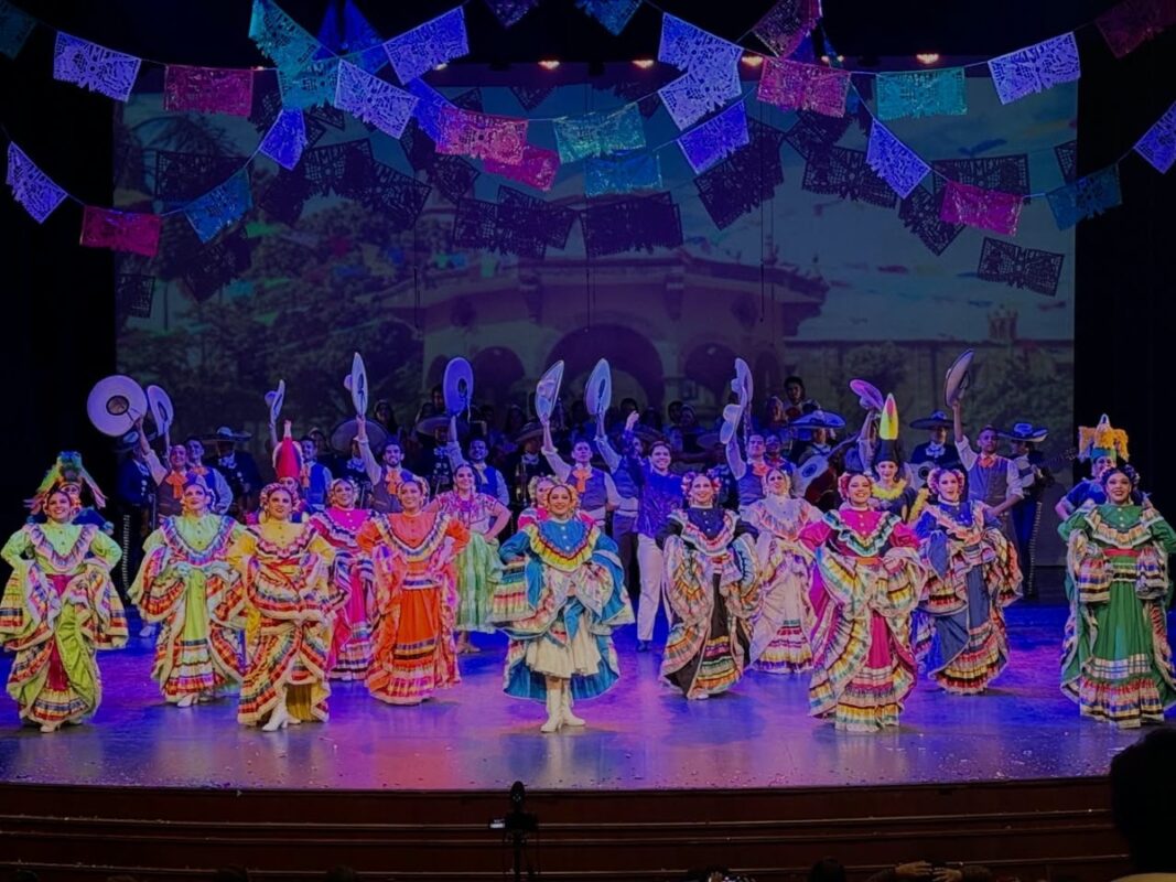 Grupo de bailarines en vestuarios tradicionales durante una presentación cultural en Michoacán.