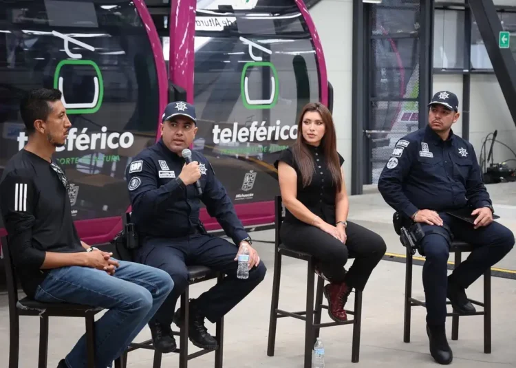 Cuatro oficiales y una mujer participan en un panel de discusión en un espacio público.