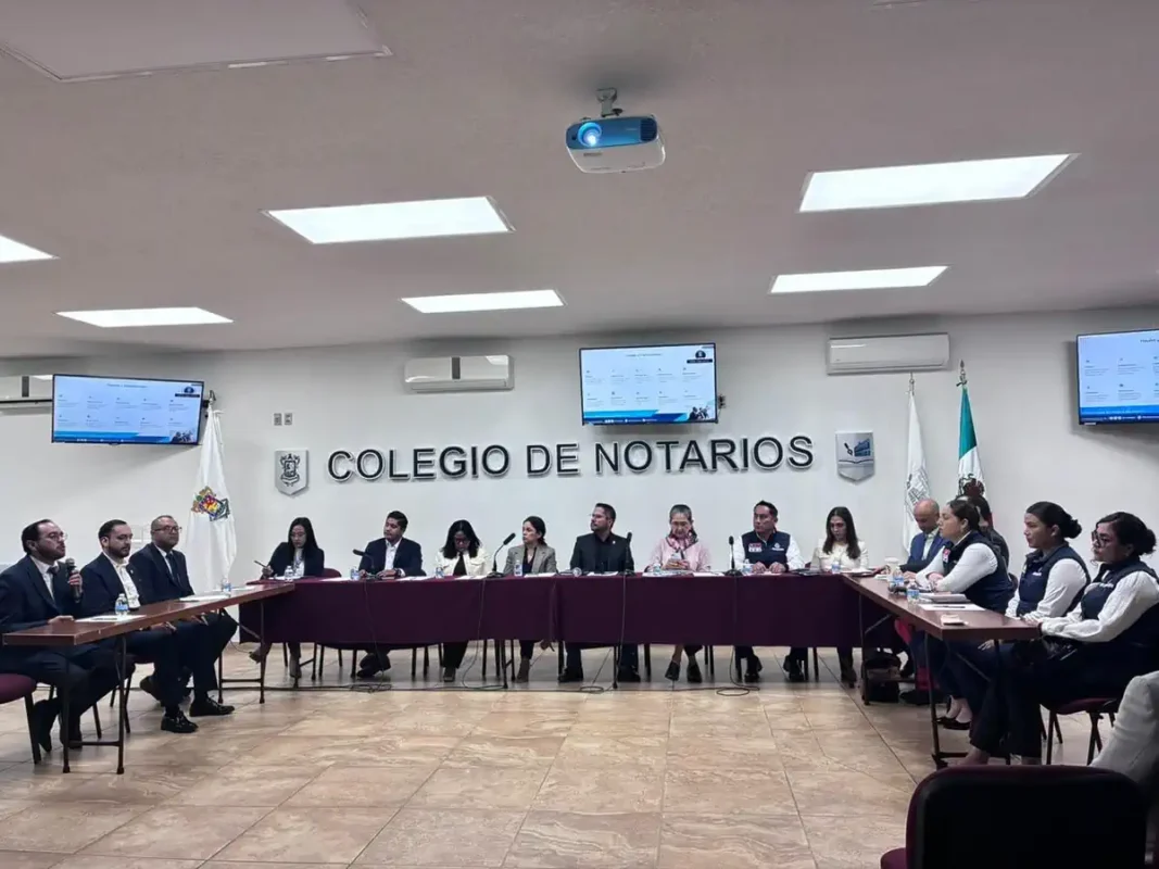 Notarios y autoridades en capacitación contra extorsión y fraude en Michoacán en sala de reuniones moderna.