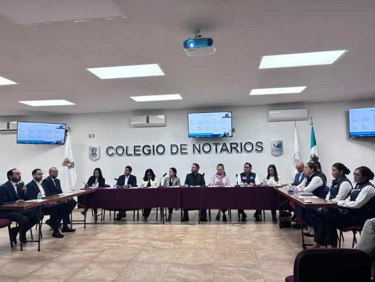 Notarios y autoridades en capacitación contra extorsión y fraude en Michoacán en sala de reuniones moderna.