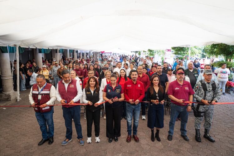 Grupo de autoridades y comunidad en ceremonia de inauguración bajo toldo blanco en Michoacán.