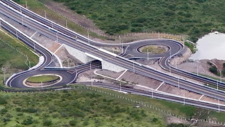 Carretera de circunvalación con curvas y rotondas en un paisaje verde y natural.