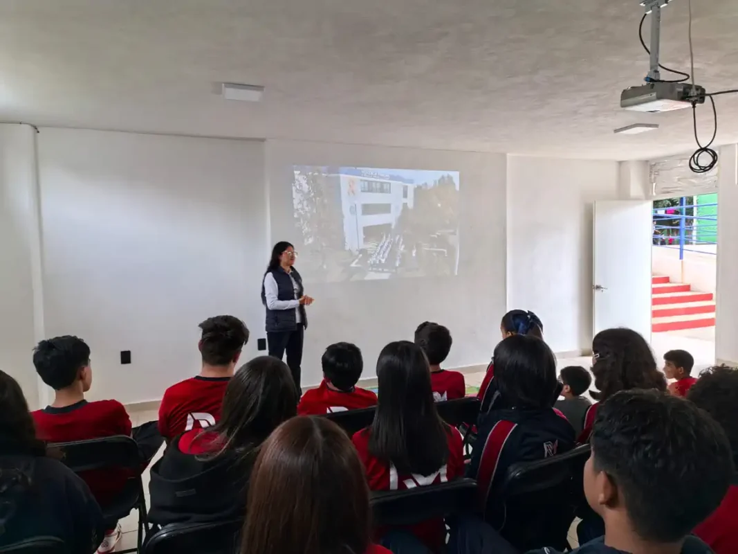 Instructor enseña a estudiantes de Morelia sobre prevención del acoso escolar en aula moderna.