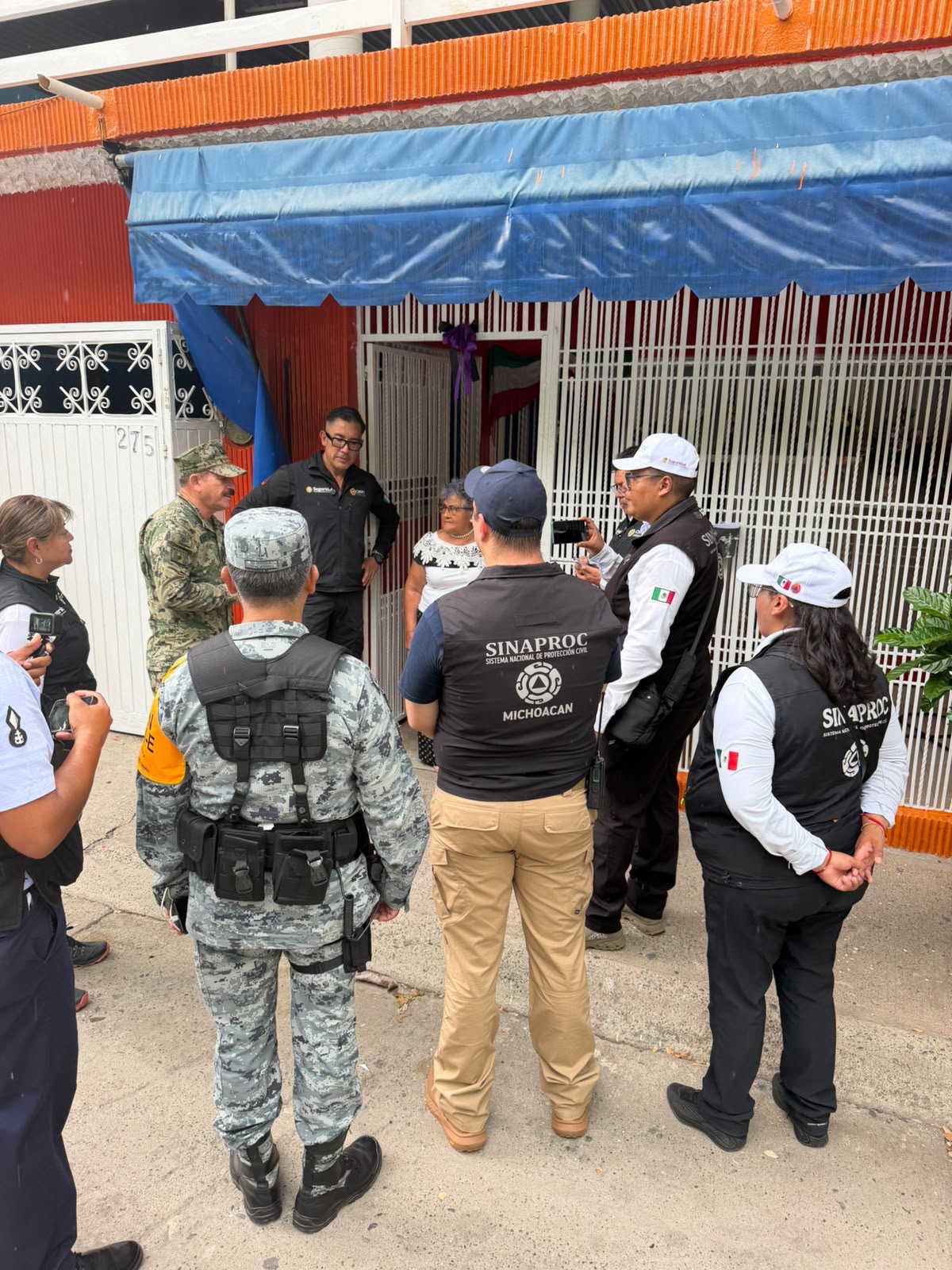 Autoridades y personal de seguridad conversan frente a un establecimiento en Michoacán.
