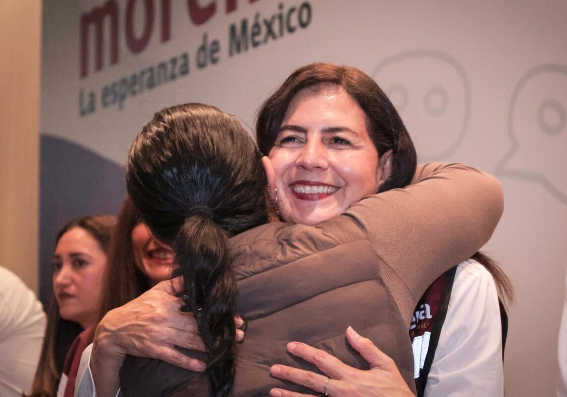Gaby Molina sonríe mientras abraza a una asistente en un evento comunitario en Michoacán.
