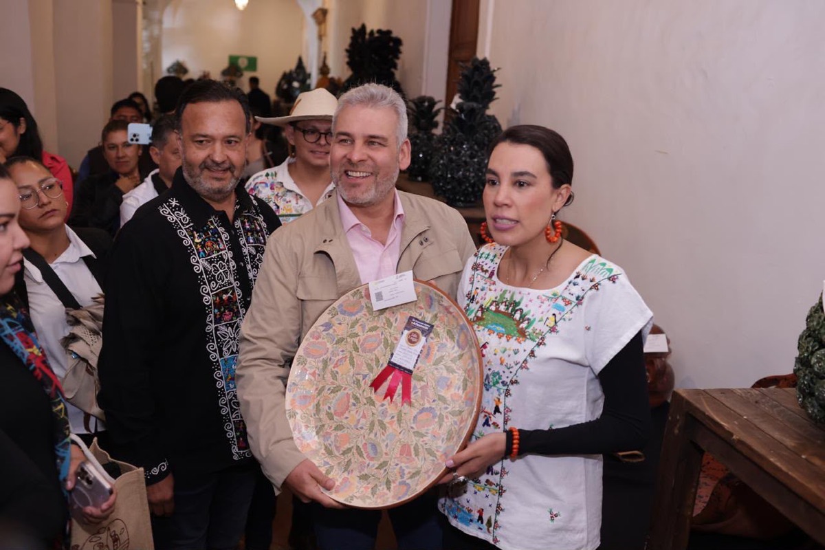 Artesanos premiados en el 57 Concurso Estatal de Artesanías de Pátzcuaro con un plato decorativo