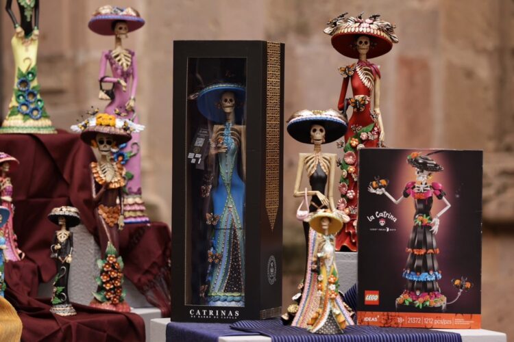 Varias figuras de calaveras vestidas con trajes coloridos y sombreros están exhibidas junto a una caja y un set de LEGO inspirado en una de ellas.